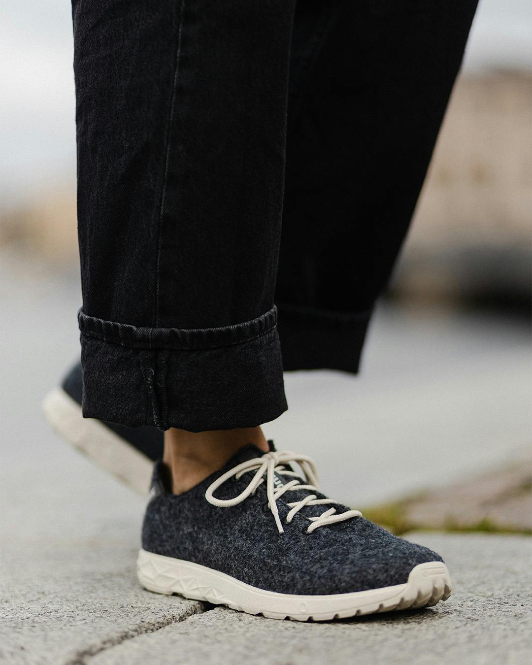 A person in Icebug wool sneakers and black jeans.