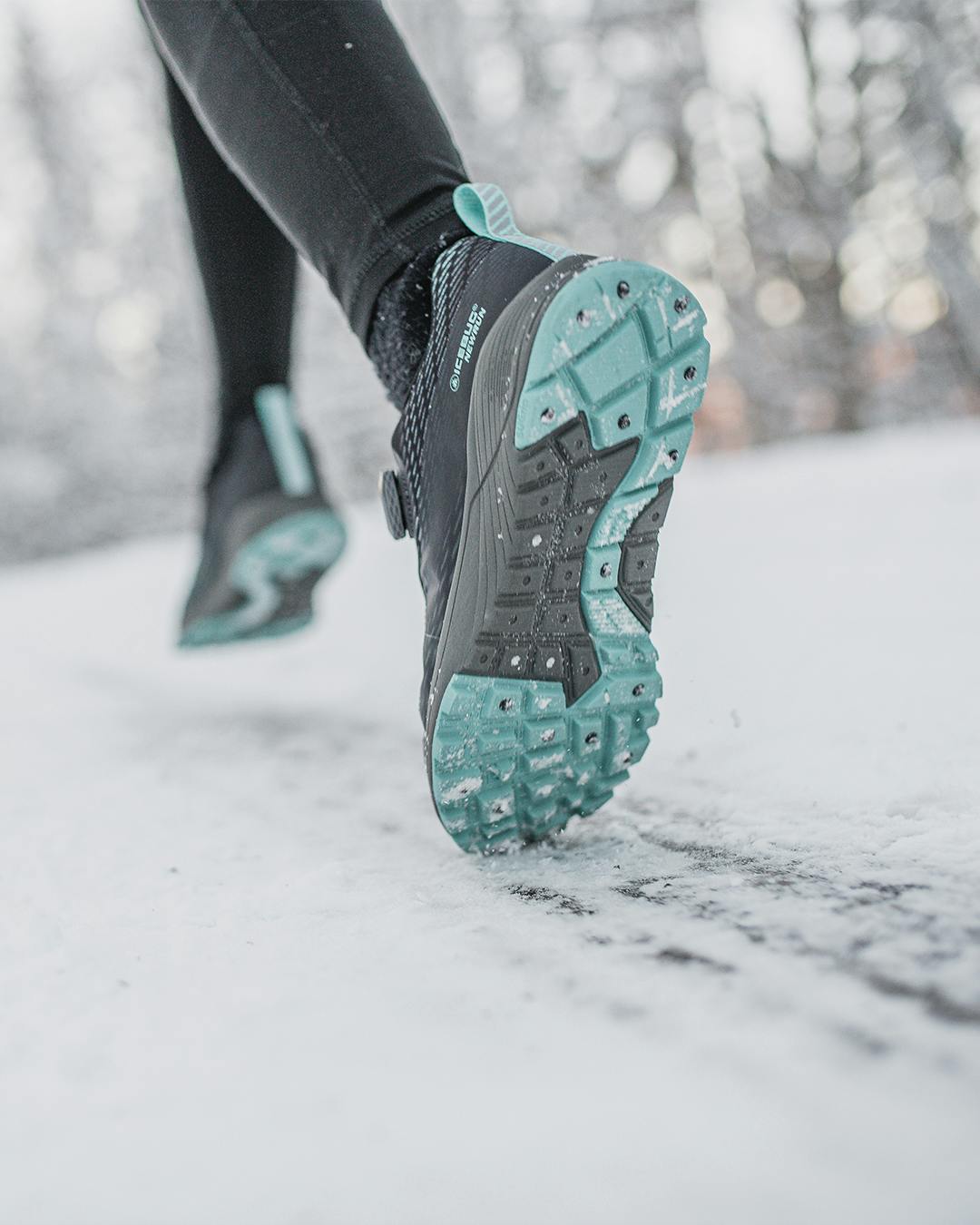 A person running on an icy road wearing winter running shoes from Icebug
