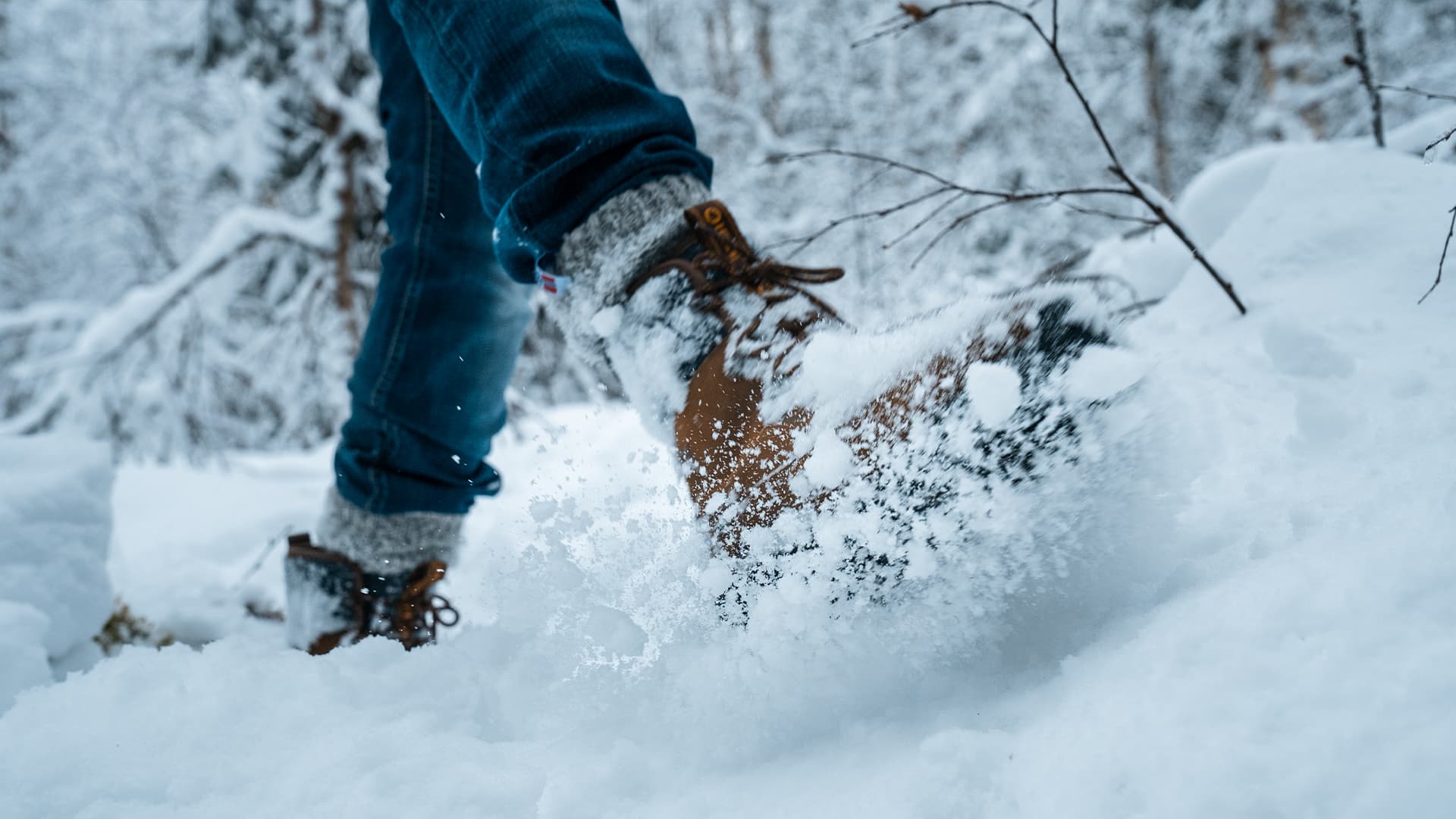 a person walking in snow with a pair of brown Icebug winter boots