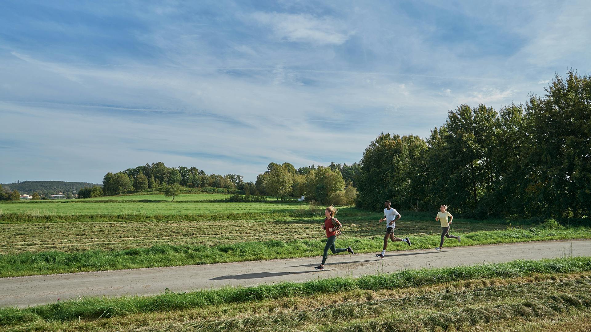 three people running on a gravel road with running shoes from Icebug