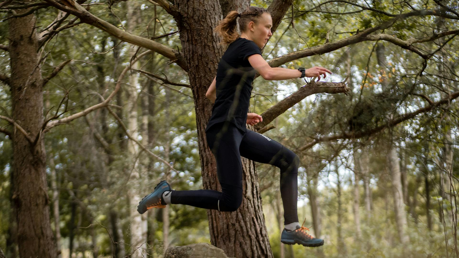 A women running in the forest wearing Icebug Trail Running Shoes
