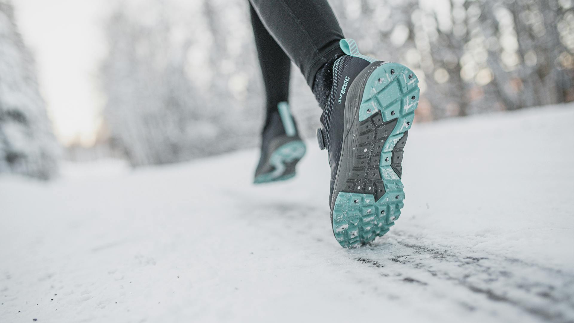 A person running on an icy road wearing winter running shoes from Icebug